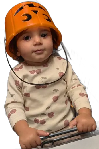 Miray, onze Bolliebal, in een winkelkarretje, met een oranje pompoenemmertje als helm